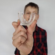 a boy holding a protective mouthguard