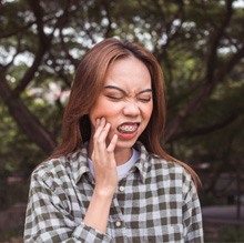 a patient with braces experiencing oral pain